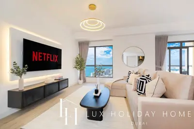 a living room with a couch and a tv at LUX The Dubai Eye Sea View Suite in Dubai