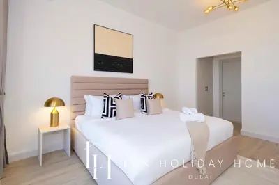 a white bedroom with two beds and a table at LUX The Dubai Eye Sea View Suite in Dubai