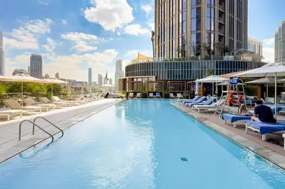 a large swimming pool with lounge chairs and buildings at GuestReady - Contemporary delight in Dubai in Dubai