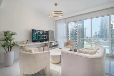 a living room with white furniture and a large window at Astonishing 2 bedroom apt full Burj Khalifa view in Dubai