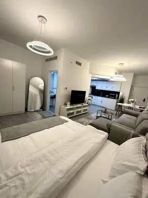 a bedroom with a large bed and a living room at Dubai Marina - Huge Luxury Studio Apartment in Dubai
