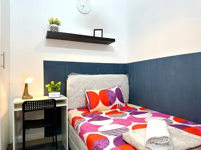 a bedroom with a bed with a table and a desk at Deluxe Couple Partition Room in Tecom Near Metro in Dubai