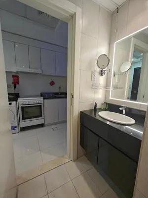 a bathroom with a sink and a counter with a mirror at LeModCasa: Smart, modern studio in JVC in Dubai