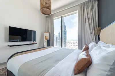 a bedroom with a large bed with a large window at Frank Porter - Forte Tower 1 in Dubai