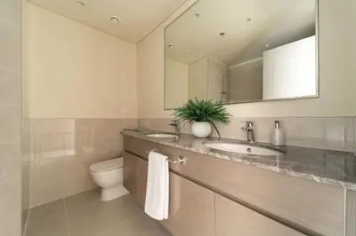 a bathroom with a sink and a toilet and a mirror at Frank Porter - Forte Tower 1 in Dubai