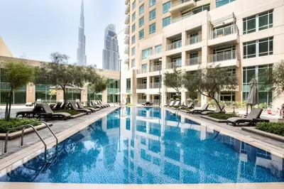 a swimming pool with chairs and a building at Frank Porter - Burj Views Central Tower in Dubai