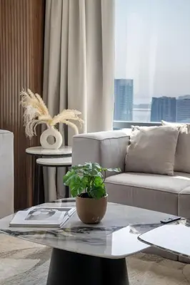 a living room with a couch and a table with a plant at Frank Porter - Burj Views Central Tower in Dubai