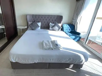 a bedroom with a large bed with two towels on it at Ensuite Rooms in CoLiving Apartments in Marina in Dubai