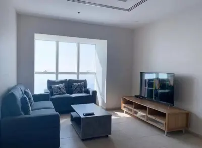 a living room with a blue couch and a tv at Ensuite Rooms in CoLiving Apartments in Marina in Dubai