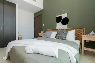a bedroom with a large bed with white sheets and pillows at Elite Escape Holiday Home - 2 BHK Getaway with Dubai Mall Access - 1503 in Dubai