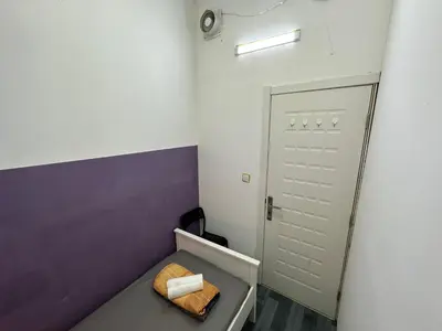 a small room with a bed and a door at Calm Partition Room Near Mashreq Metro in Dubai