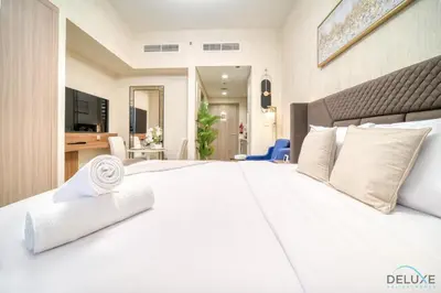 a bedroom with a white bed and a desk at Comfortable Studio Apartment at Azizi Riviera 30, Al Merkadh by Deluxe Holiday Homes in Dubai