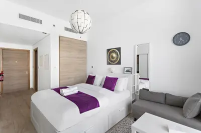 a white bedroom with a large bed and a couch at Summer offer! All Inclusive! Prime Location in Dubai