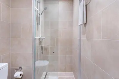 a shower with a glass door in a bathroom at STAY BY LATINEM Luxury 1BR Holiday Home CVR A2403 near Burj Khalifa in Dubai