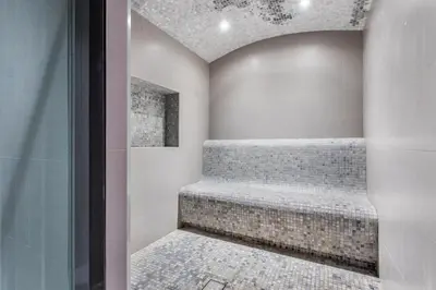 a walk in shower with a bench in a room at STAY BY LATINEM Luxury 1BR Holiday Home CVR A2403 near Burj Khalifa in Dubai