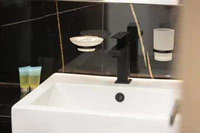 a white sink in a bathroom with a mirror at Spacious Balcony, King Bed, Pool at JVC Dubai in Dubai