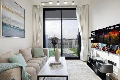 a living room with a couch and a large window at Spacious Balcony, King Bed, Pool at JVC Dubai in Dubai