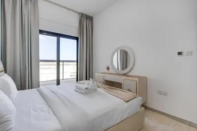 a bedroom with a white bed and a mirror at Mira Holiday Homes -Newly 2 bedroom close to metro. in Dubai