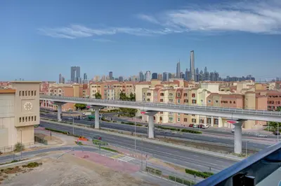 a bridge over a highway with a city in the background at Mira Holiday Homes -Newly 2 bedroom close to metro. in Dubai