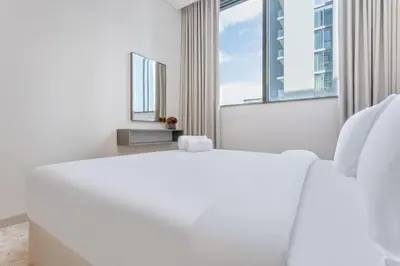 a white bedroom with a large bed and a window at STAY BY LATINEM Luxury 1BR Holiday Home CVR A2504 near Burj Khalifa in Dubai