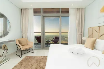 a bedroom with a large white bed with a view at Oraya - Paramount Midtown Luxurious 2BR with Sea View in Dubai