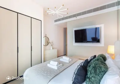 a bedroom with a bed with a tv on the wall at 2ndHome - Address Beach Resort, Tower 1, JBR in Dubai