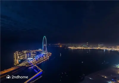 a view of a city at night with a ferris wheel at 2ndHome - Address Beach Resort, Tower 1, JBR in Dubai
