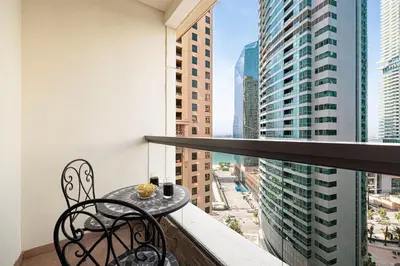 a balcony with a table and chairs on a building at Salt of the Ocean in JBR by Lagom in Dubai