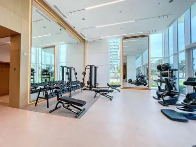 a gym with a lot of treadmills and machines at La Vie, JBR - Spacious One Bedroom in Dubai