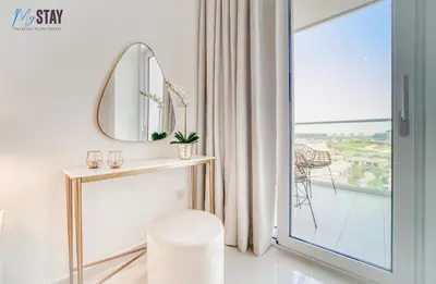 a white room with a mirror and a stool at Lovely One Bedroom Apartment in Dubai