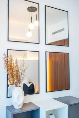 a wall with framed pictures and a vase on a table at The Dreamer 1BR Burj Khalifa View Business Bay in Dubai