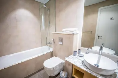 a bathroom with a sink and a toilet and a tub at The Cinephile Burj Khalifa View 2BR Dubai in Dubai