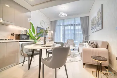 a kitchen and living room with a table and chairs at Serene 1BR Apartment in Azizi Riviera 27, Al Merkadh by Deluxe Holiday Homes in Dubai