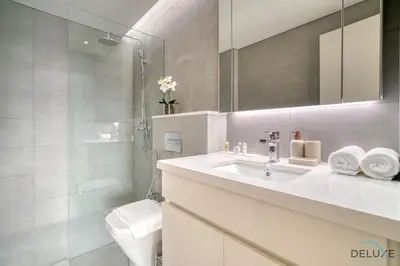 a white bathroom with a sink and a toilet at Welcoming 1BR Apartment in Ahad Residences Business Bay by Deluxe Holiday Homes in Dubai