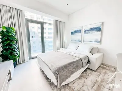 a white bedroom with a bed and a large window at SEVEN PALM by Design Studio 1BR in Dubai