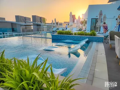 a swimming pool with boats in the water on a building at SEVEN PALM by Design Studio 1BR in Dubai