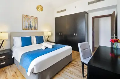 a bedroom with a large bed and a desk at Stunning 3 plus 1 BR Apartment on JBR Beach with Marina View Near Mall, Metro & Cinemas - By Sunkissed Holiday Homes in Dubai