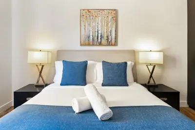 a bedroom with a large bed with blue pillows at Stunning 3 plus 1 BR Apartment on JBR Beach with Marina View Near Mall, Metro & Cinemas - By Sunkissed Holiday Homes in Dubai