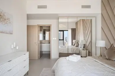 a white bedroom with a large bed and a mirror at *Views of Burj Khalifa Fountain* in Dubai