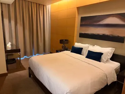 a bedroom with a large white bed with blue pillows at Emaar Residence Fashion Avenue - formerly Address Dubai Mall in Dubai