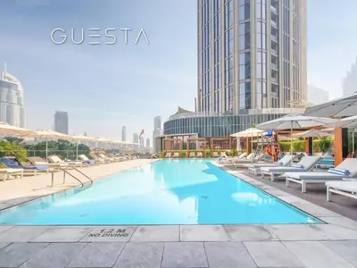 a swimming pool with chairs and umbrellas in a city at Address Residences Dubai Opera, Downtown Dubai in Dubai