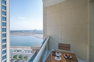 a balcony with a table and a view of the ocean at Budget Friendly Production City in Dubai