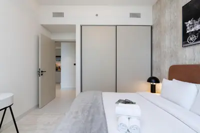 a bedroom with a white bed and a desk at Elegant 1BHK Beach Front Perfect Getaway in Dubai