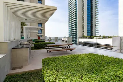 a rooftop patio with benches and tables on a building at Elegant 1BHK Beach Front Perfect Getaway in Dubai