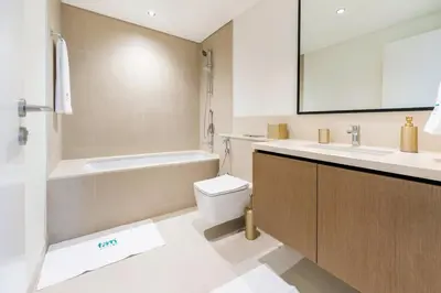 a bathroom with a sink and a toilet and a mirror at FAM Living - Modern 3 Beds+Maidroom Home in Downtown Burj view in Dubai