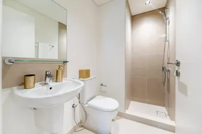 a bathroom with a toilet and a sink and a shower at FAM Living - Modern 3 Beds+Maidroom Home in Downtown Burj view in Dubai