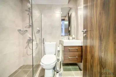 a bathroom with a toilet and a glass shower at Exquisite 4BR Townhouse at DAMAC Hills 2, Dubailand by Deluxe Holiday Homes in Dubai