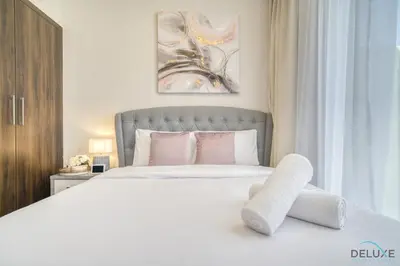 a bedroom with a large white bed with pink pillows at Exquisite 4BR Townhouse at DAMAC Hills 2, Dubailand by Deluxe Holiday Homes in Dubai