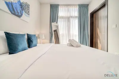 a bedroom with a large white bed with blue pillows at Exquisite 4BR Townhouse at DAMAC Hills 2, Dubailand by Deluxe Holiday Homes in Dubai