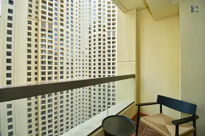 a room with a balcony with a view of tall buildings at Luxury Escapes - Charming 3BR plus maids Apt near JBR Beach - Sadaf 1 in Dubai